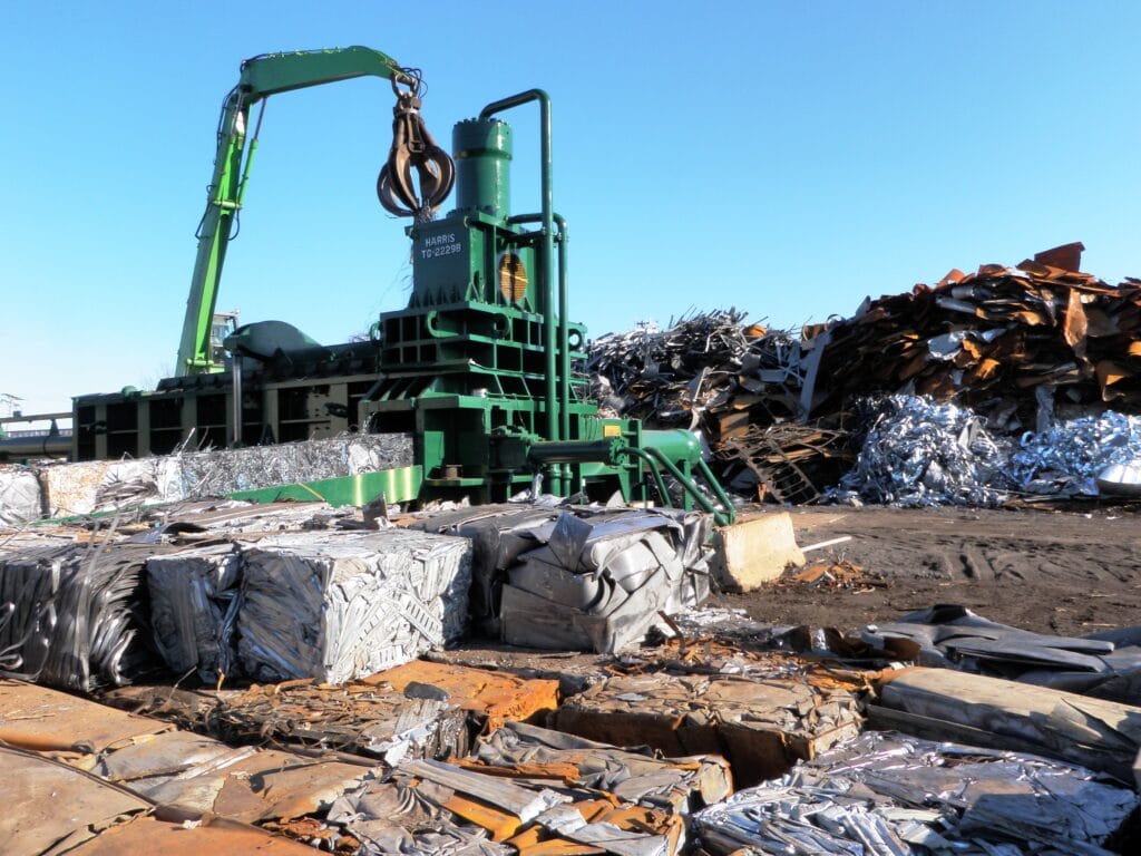 Scrap Metal Services green crane that handles metal scrap in the scrap yard.